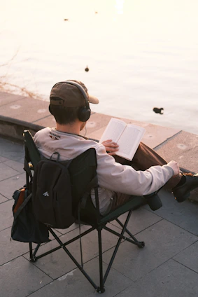 A person sitting in a chair reading a book