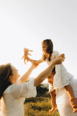 A woman holding a baby up in the air