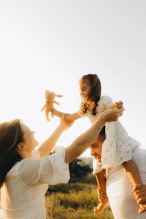 A woman holding a baby up in the air