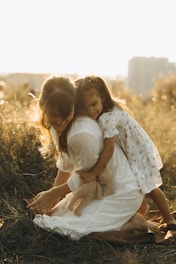 Two little girls hugging each other in a field