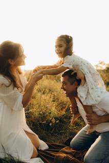 A man holding a little girl on his shoulders