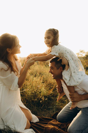 A man holding a little girl on his shoulders