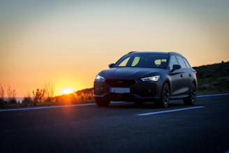 A car driving down a road at sunset