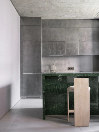 A kitchen with a marble counter top next to a bar
