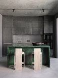 A kitchen with a marble counter top and two stools