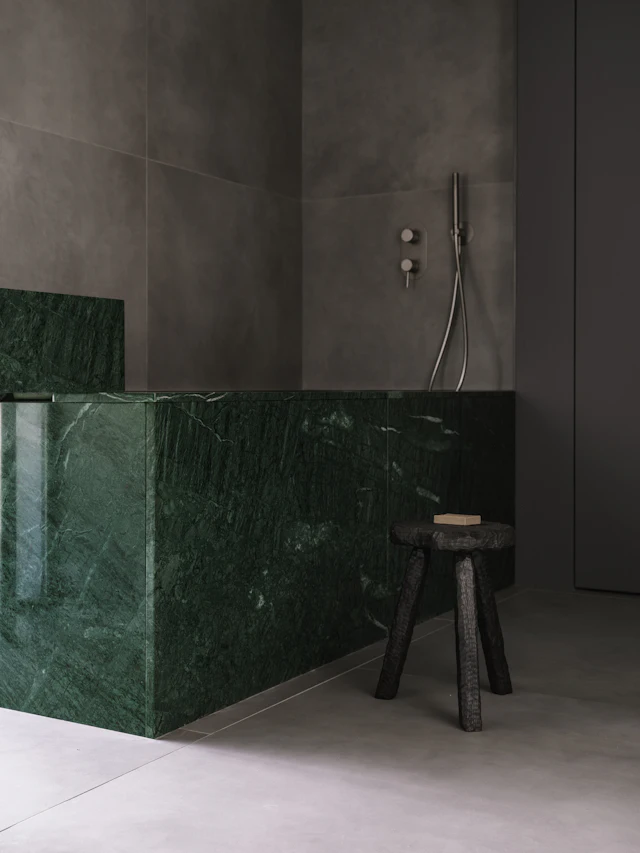 A bathroom with a green marble counter top