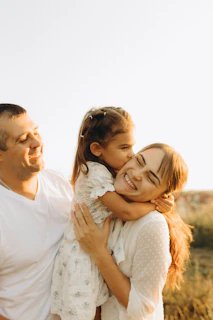A man holding a little girl in a field