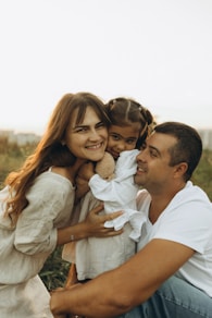 A man and two girls are sitting on a man's lap