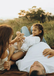A man laying on the ground with two little girls