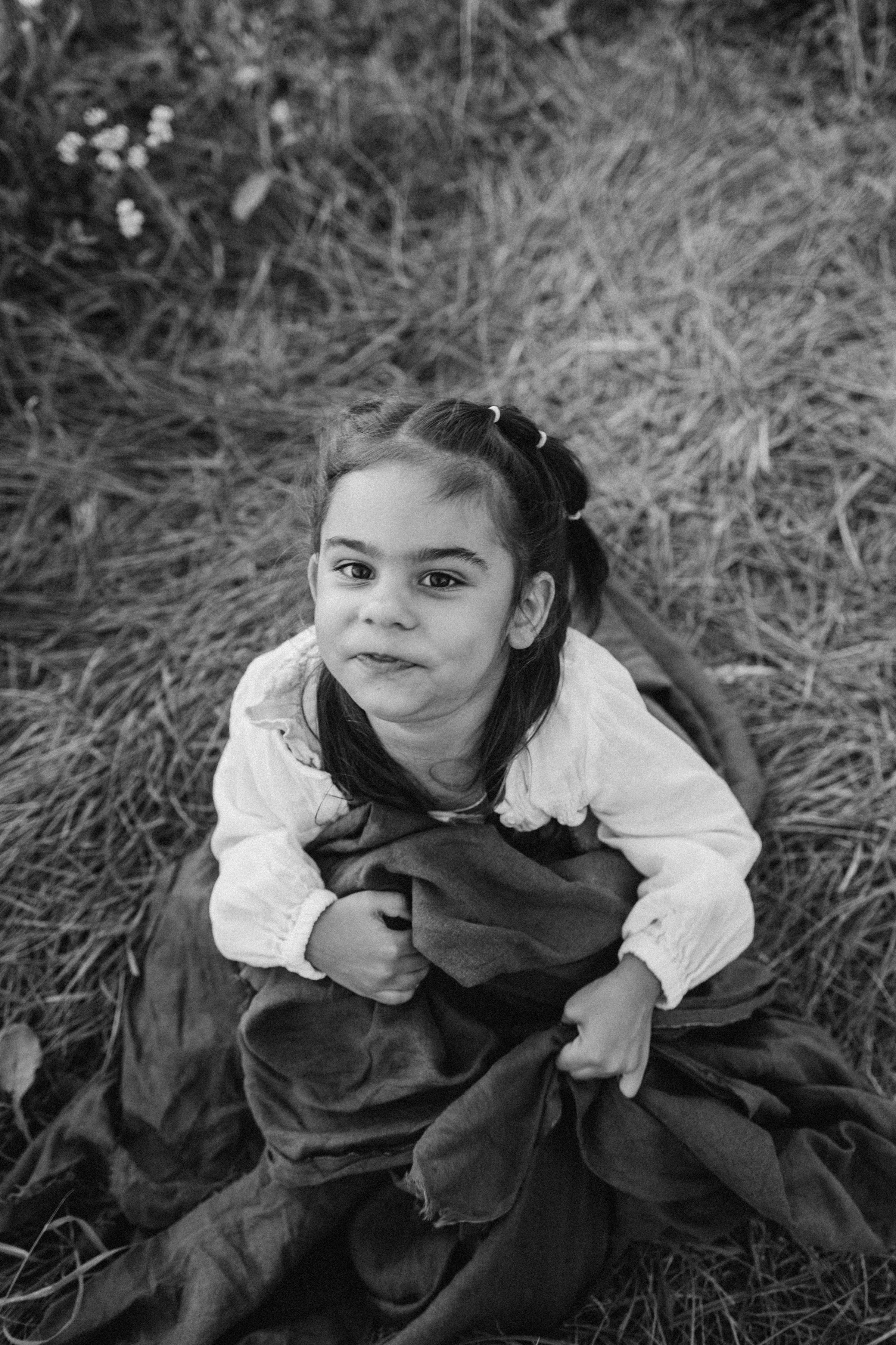 A young girl sitting on the ground in a field photo – Free Portrait ...
