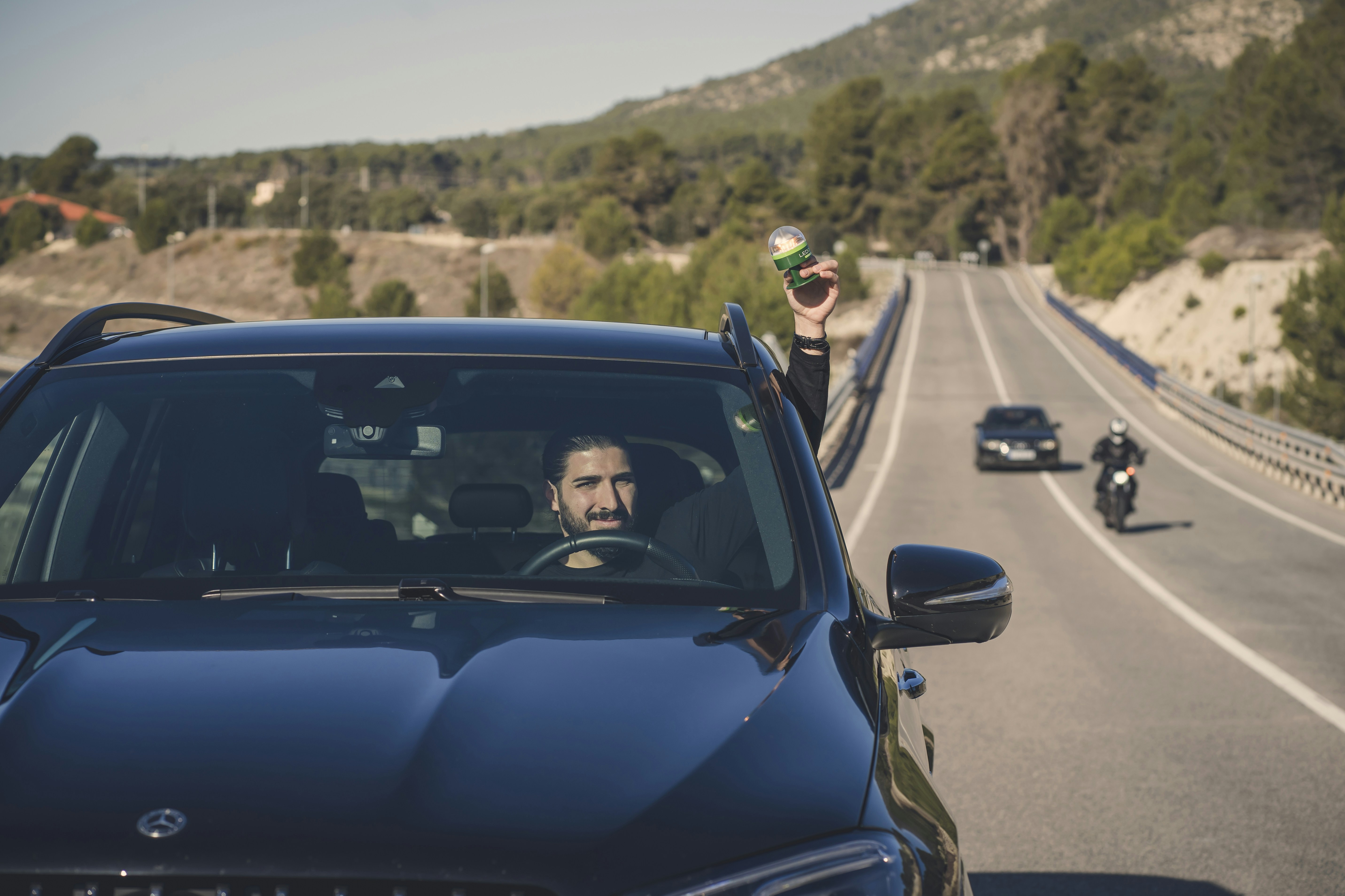 Un coche que circula por una carretera junto a una motocicleta