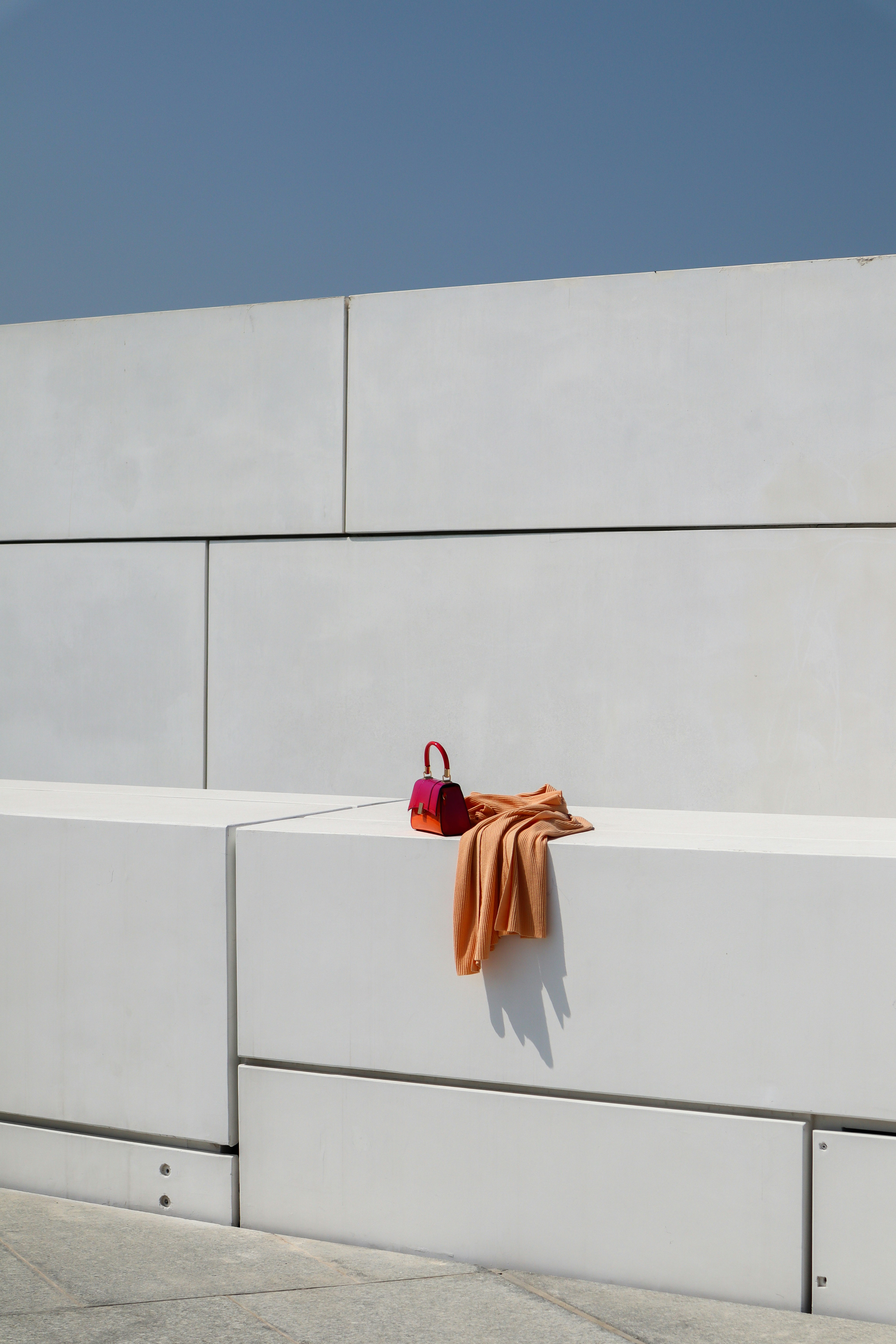 A pair of red shoes sitting on a white bench