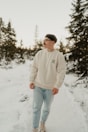 A man standing in the snow with trees in the background
