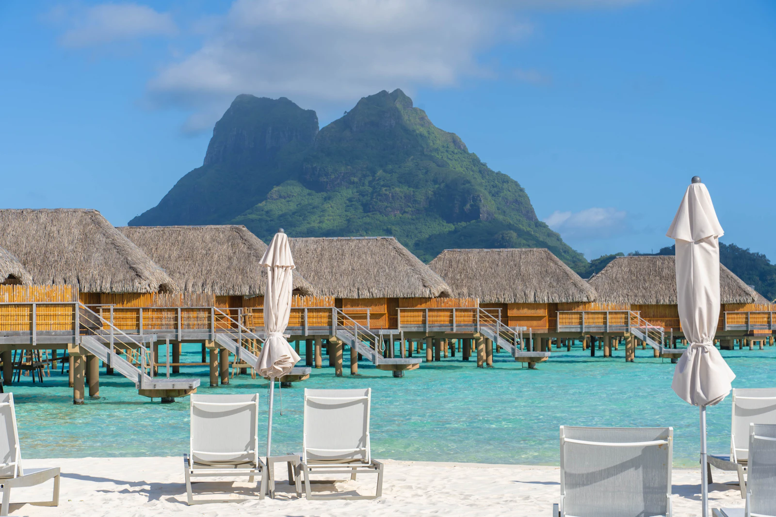 Overwater bungalows in the Bora Bora lagoon below Mount Otemanu