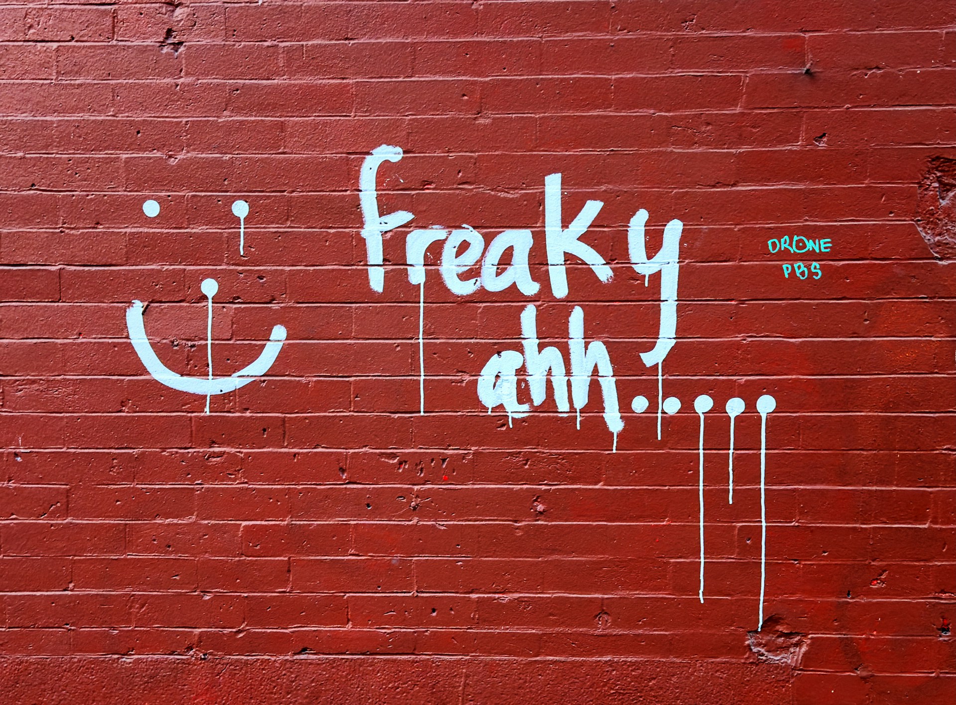 A red brick wall with graffiti written on it