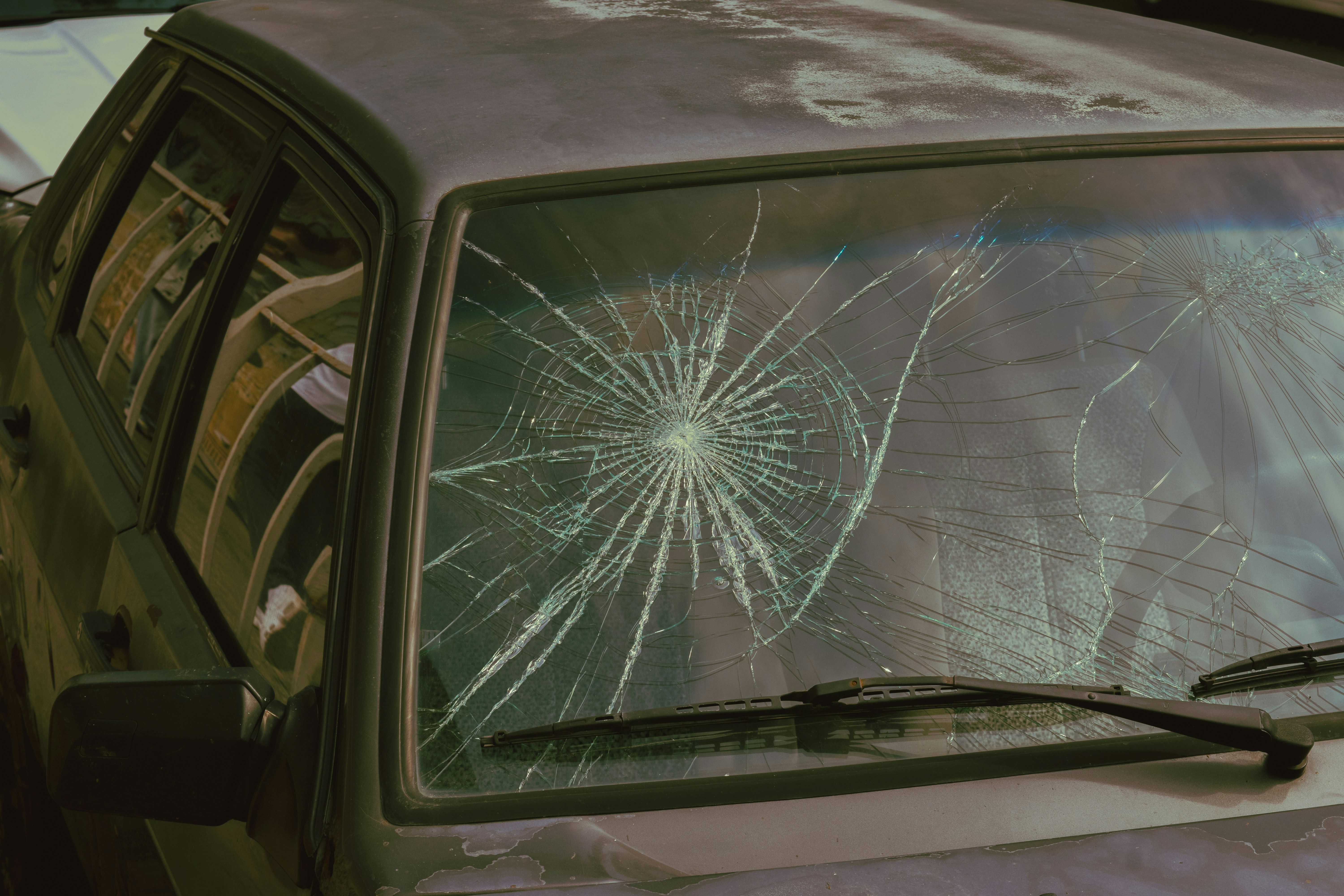 A broken windshield of a car with a broken windshield