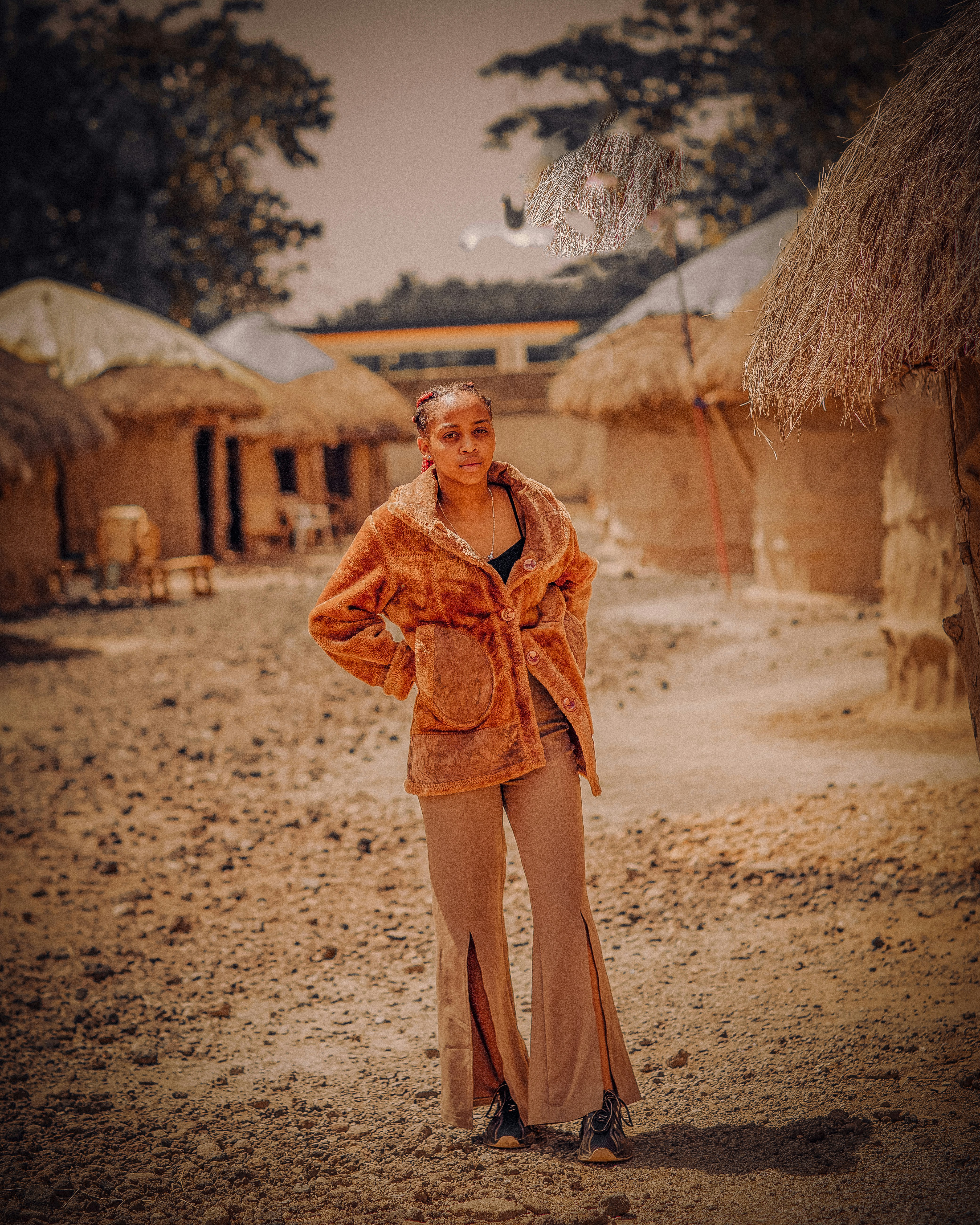 A woman standing in front of straw huts