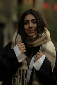 A woman wearing a scarf and a black jacket
