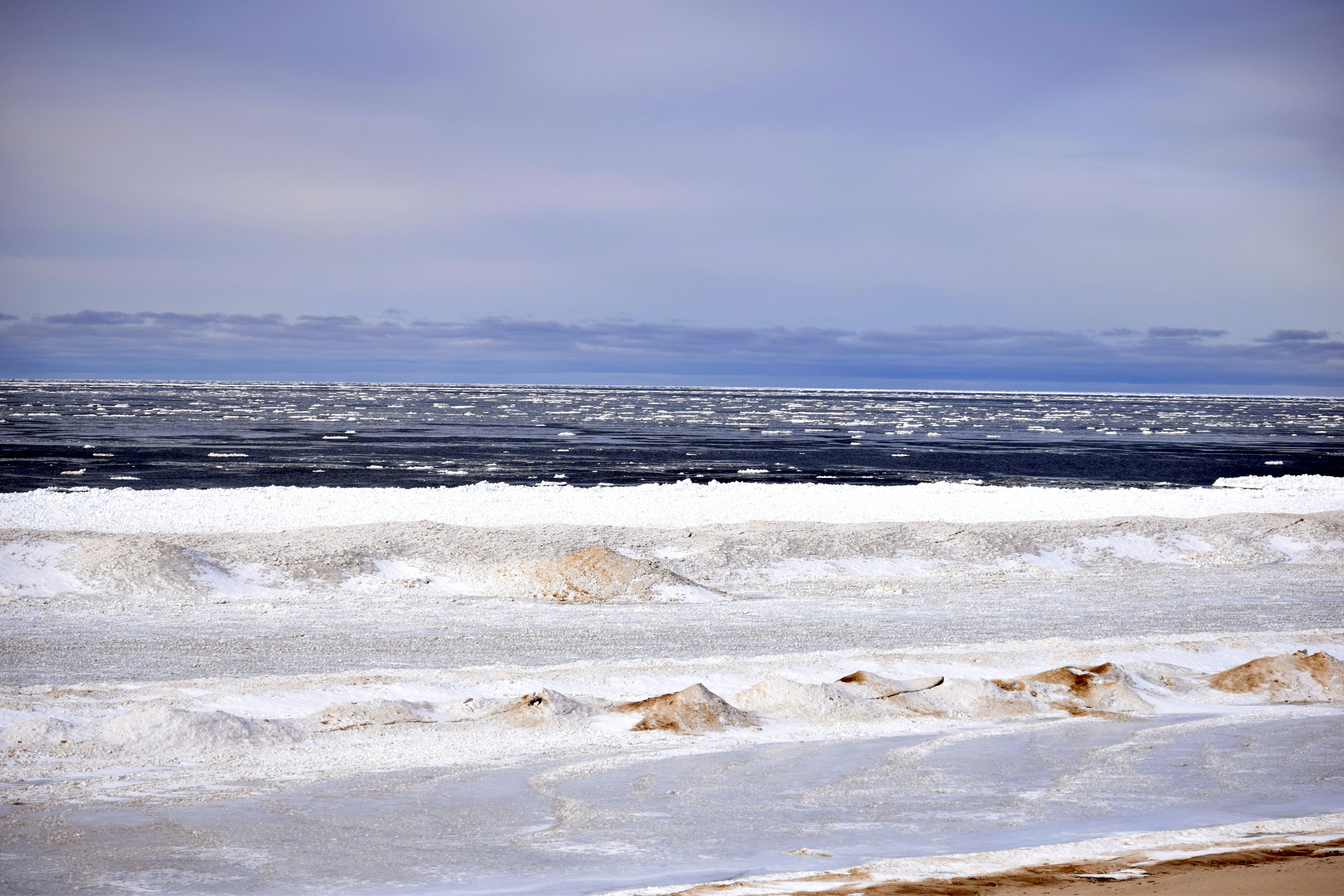 A person walking on the beach with a surfboard