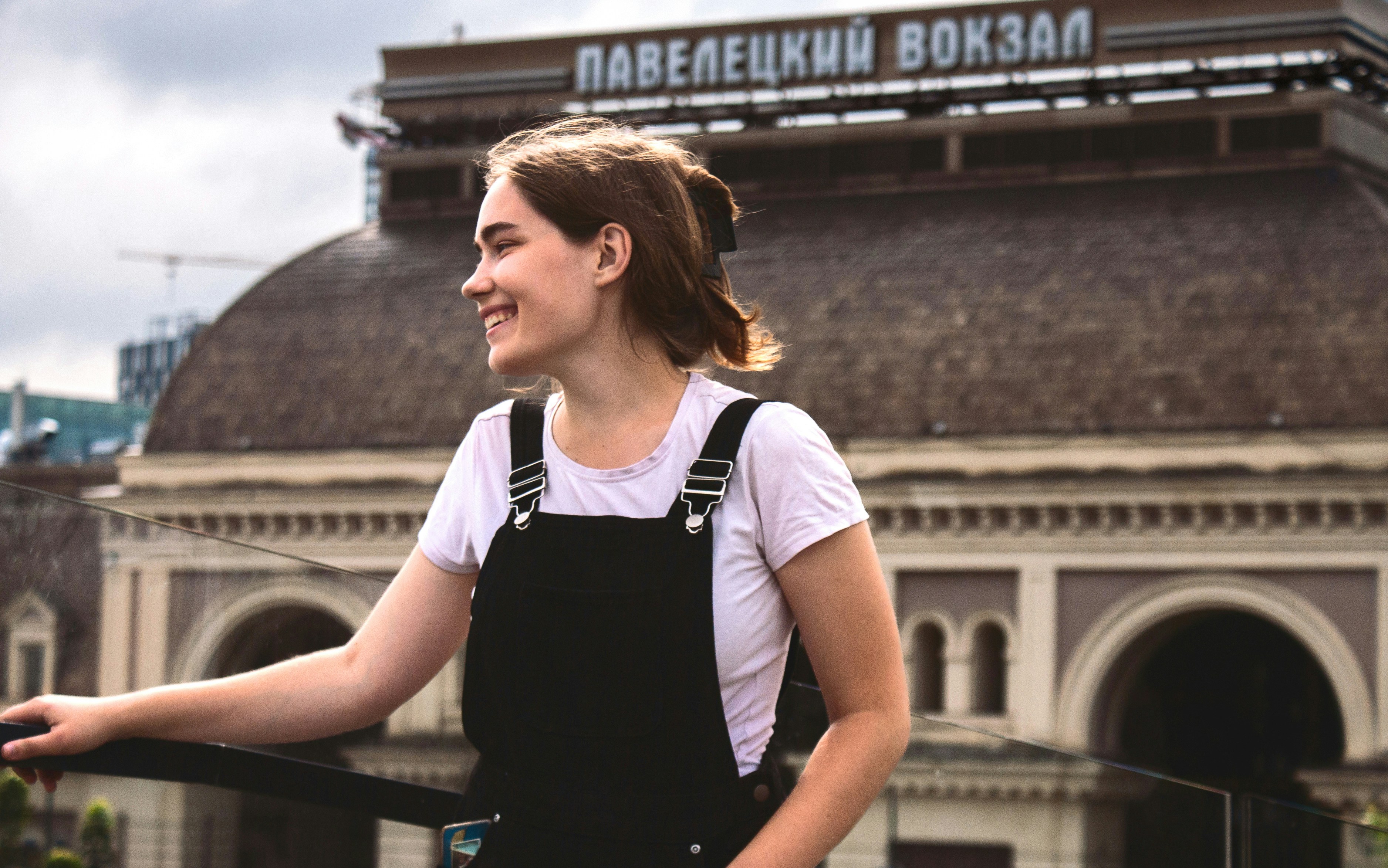 Une femme avec un tablier noir se tient à l’extérieur