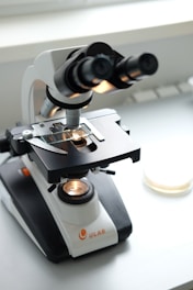A microscope sitting on top of a white table