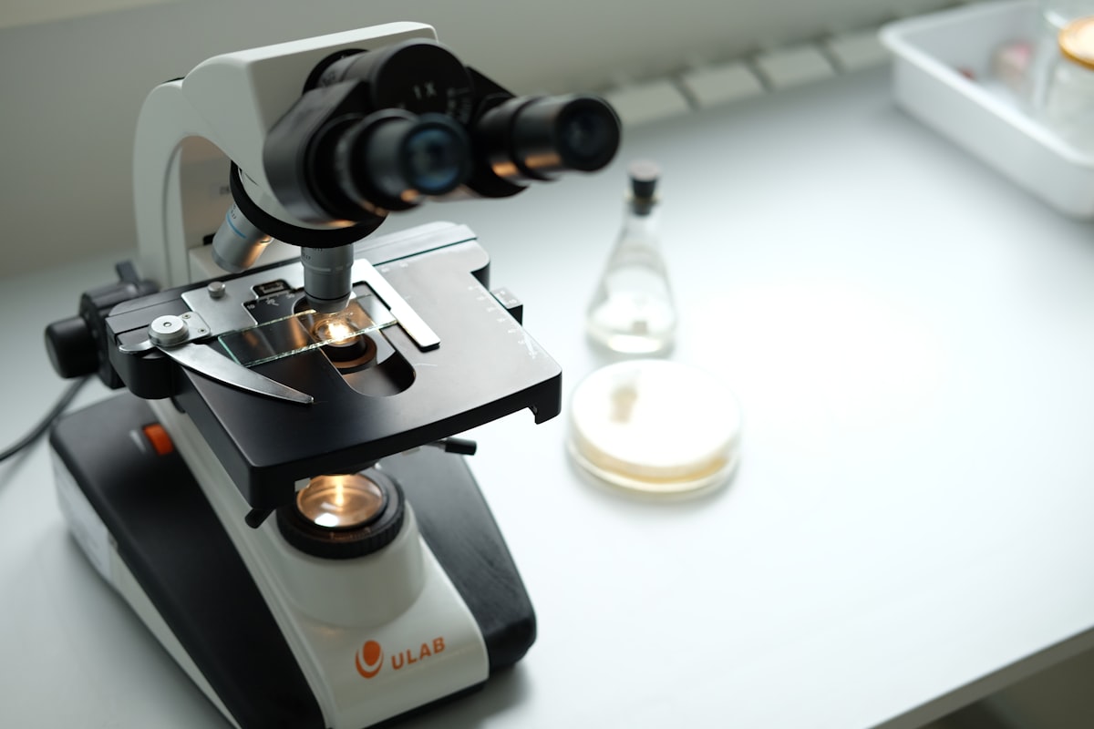 A microscope and laboratory equipment representing pharmaceutical research and Moderna's pivot from vaccines to oncology