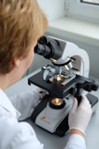 A woman looking through a microscope at something