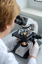A woman looking through a microscope at something