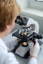 A woman looking through a microscope at something
