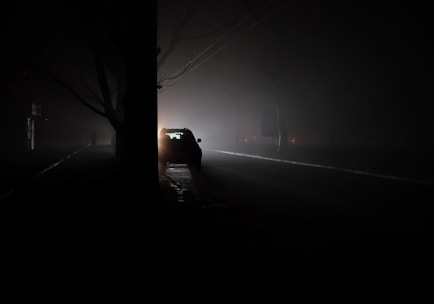 A car driving down a dark road at night