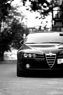 A black and white photo of a car parked on the side of the road