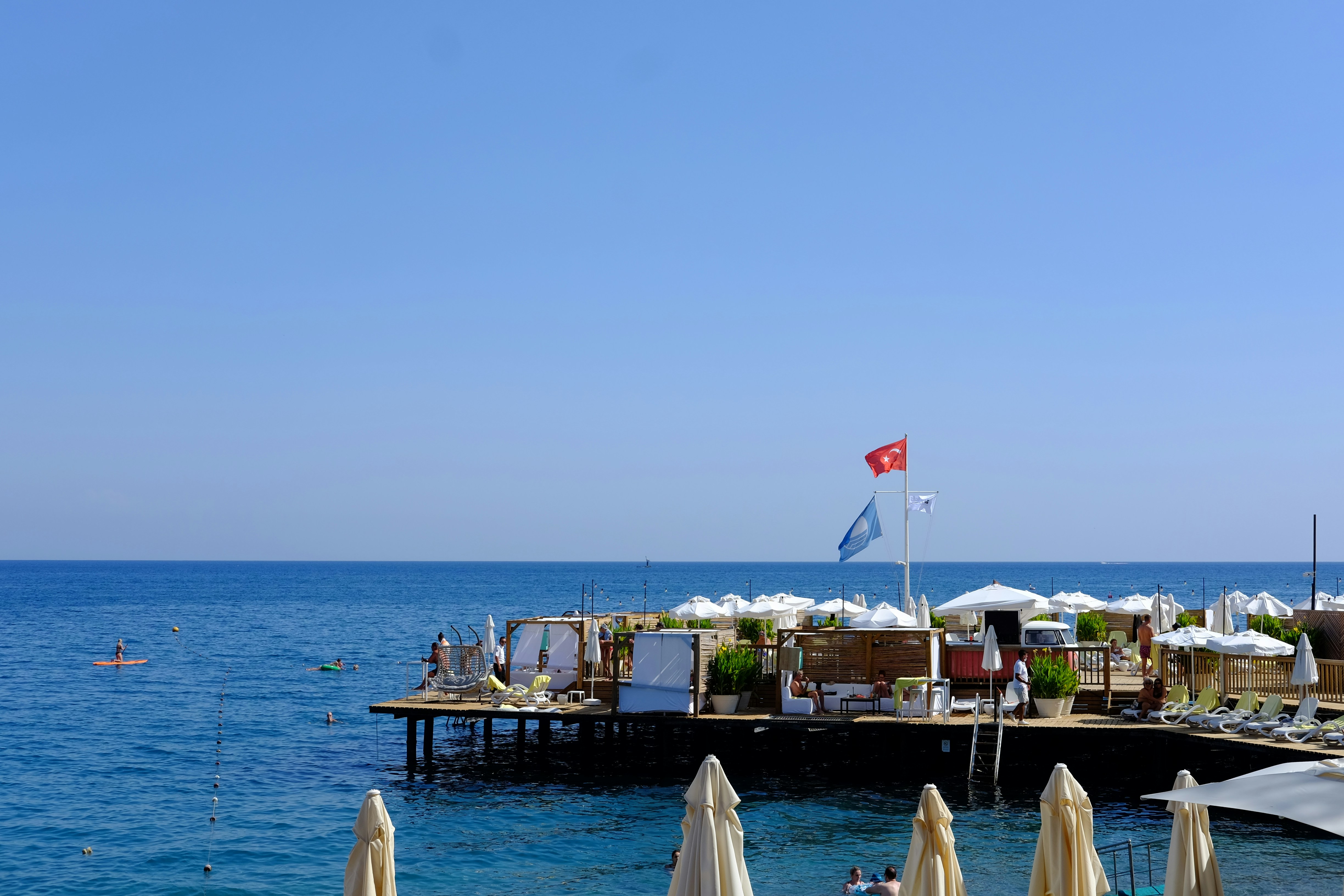 A group of umbrellas sitting on top of a pier, 