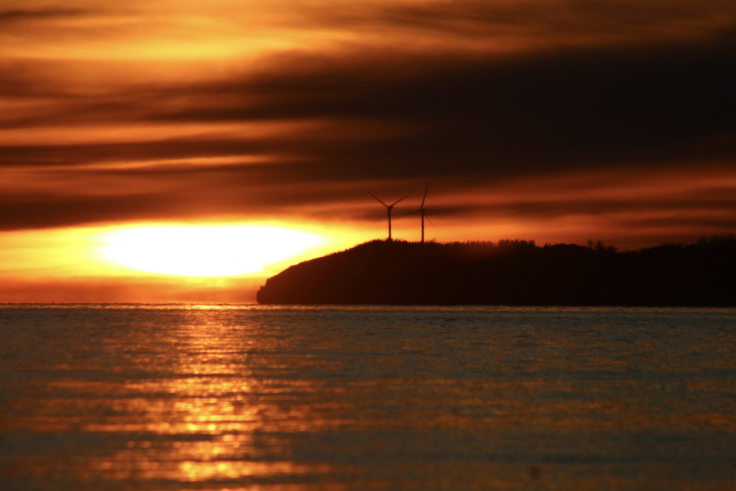 A large body of water with a sunset in the background