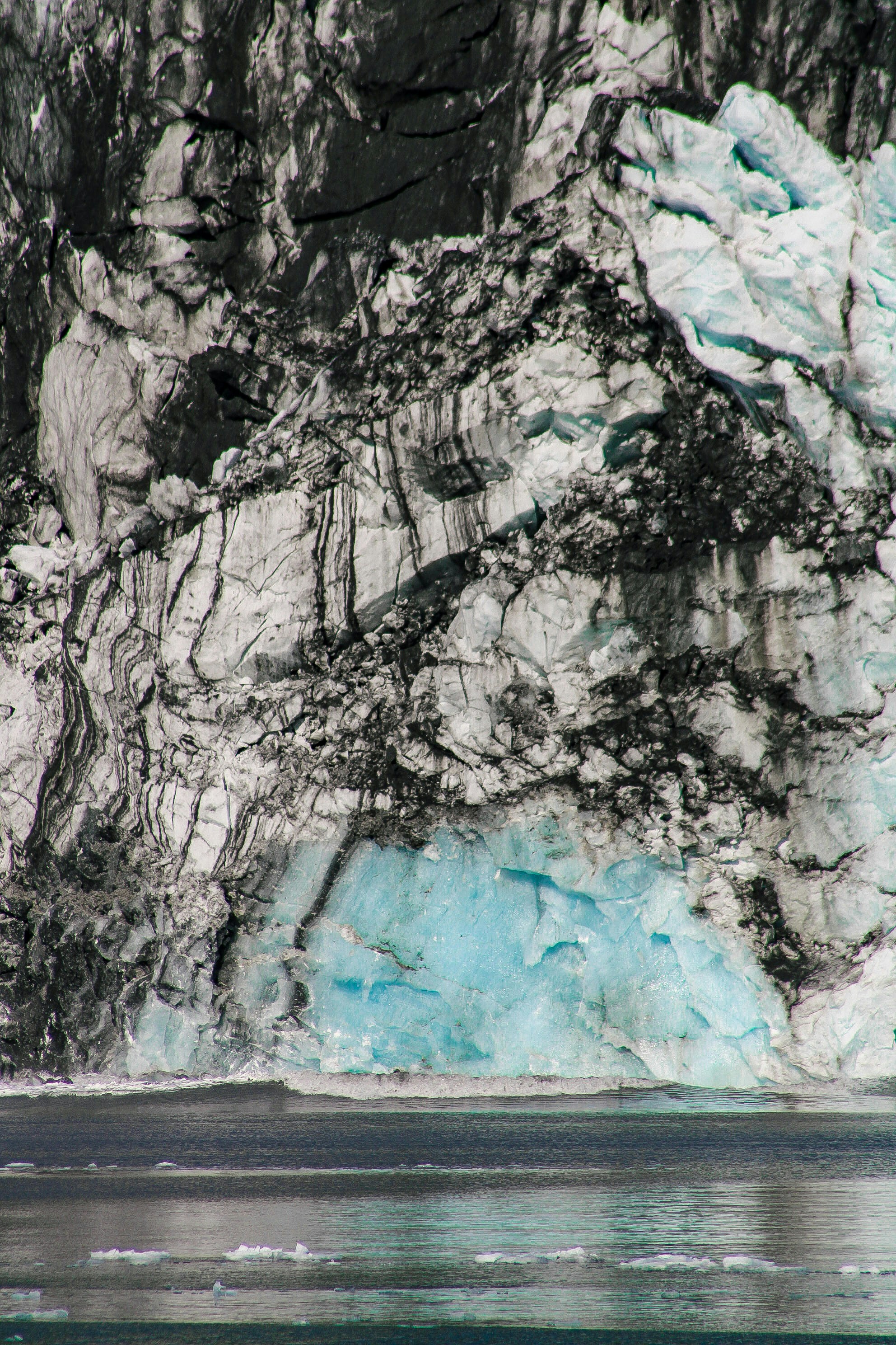 A large iceberg that is melting off of the side of a mountain