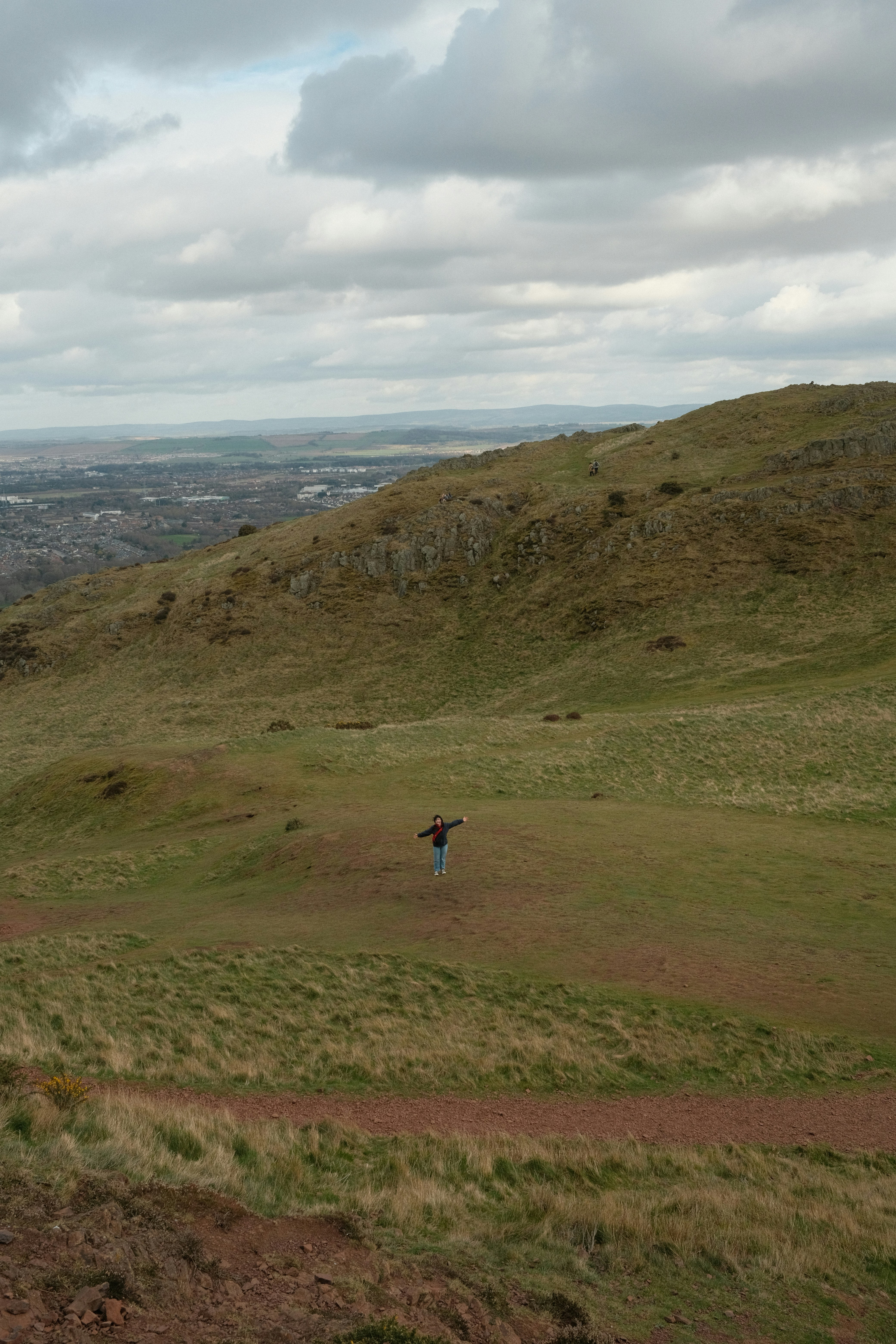 A person flying a kite on a grassy hill