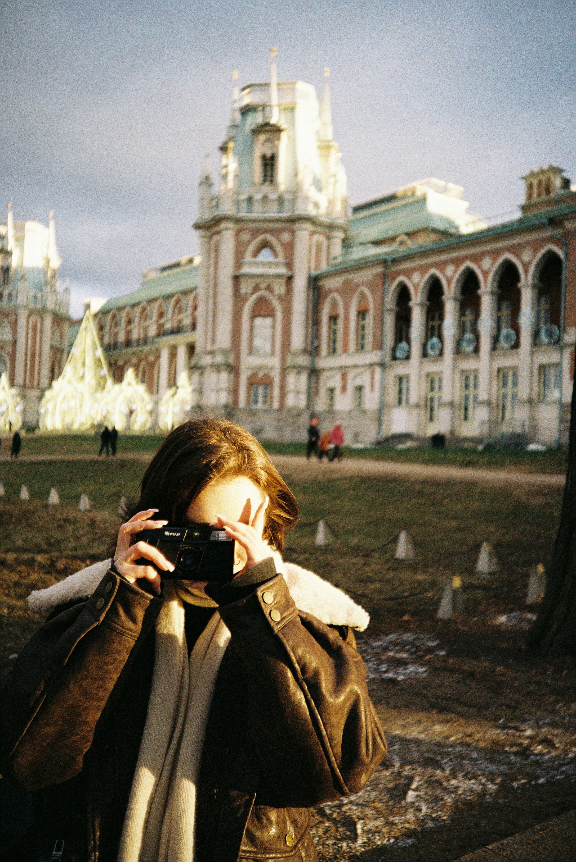 A woman taking a picture of a building with a camera