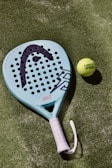 A tennis racket and a tennis ball on a court