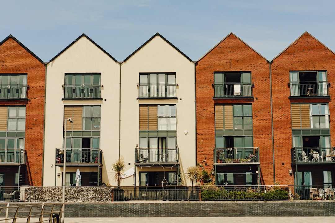 A row of red brick buildings next to a body of water, Townhouses