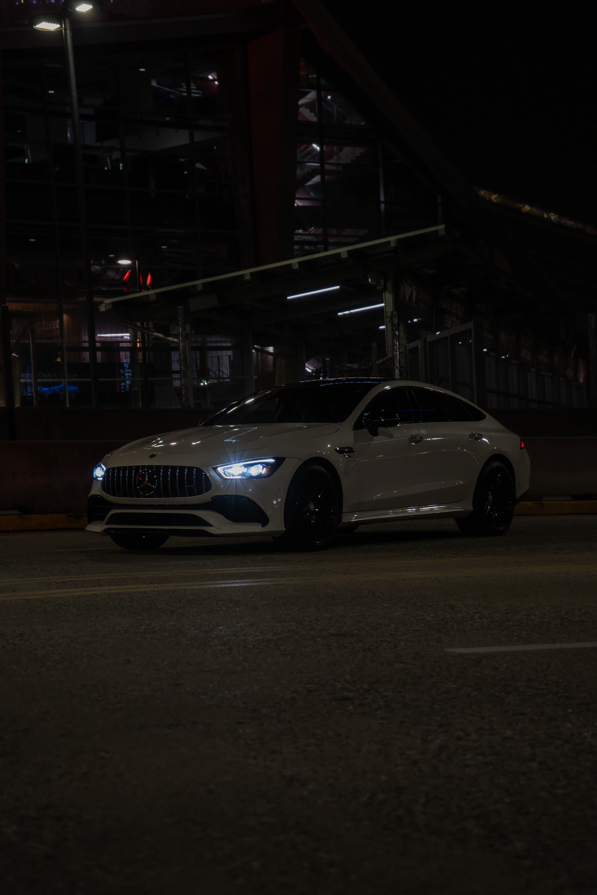 A car parked on the side of the road at night