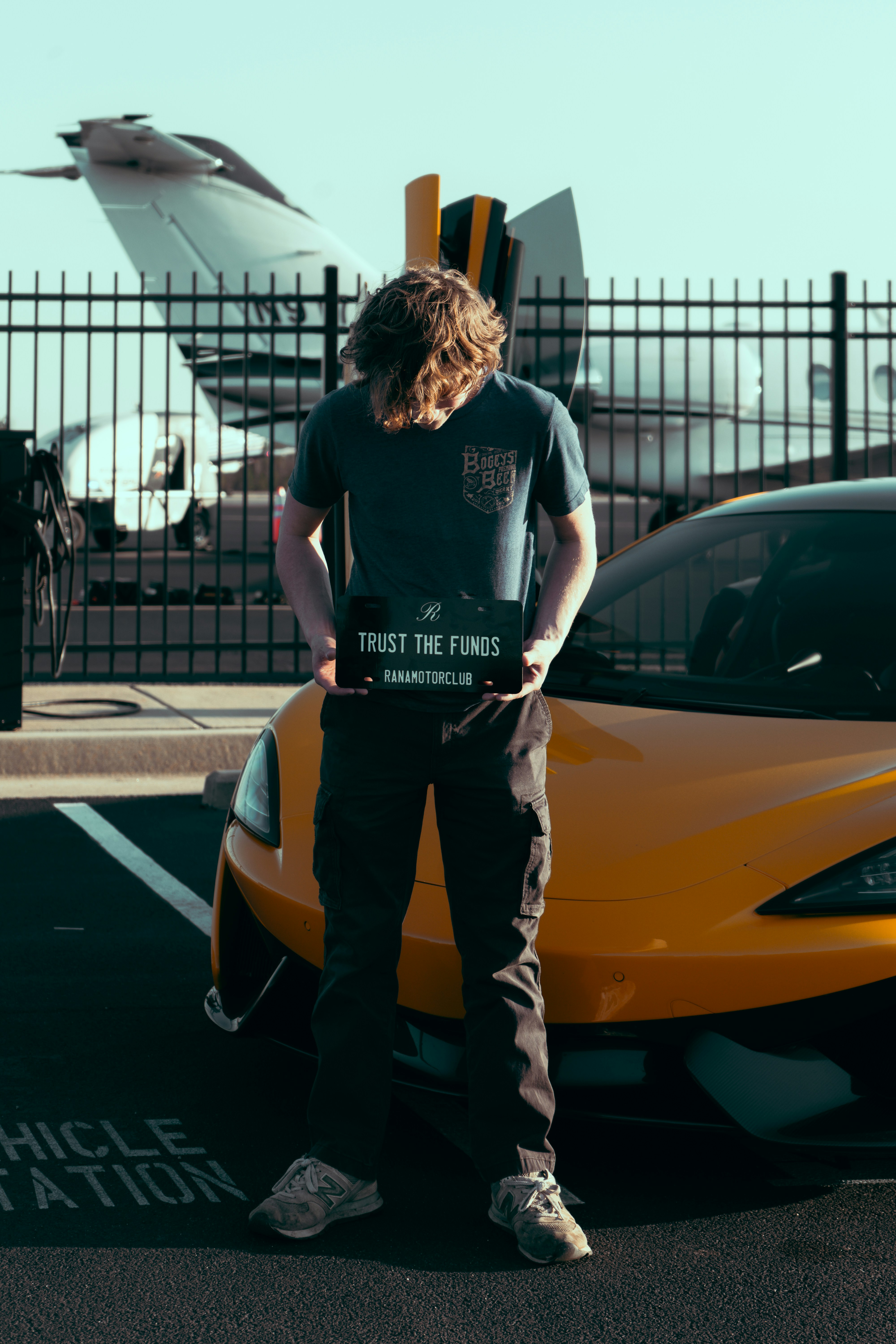 A man standing next to a yellow sports car