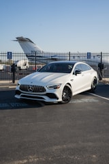 A white car is parked in a parking lot