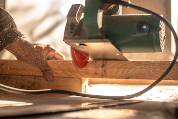 A man sanding a piece of wood with a sander