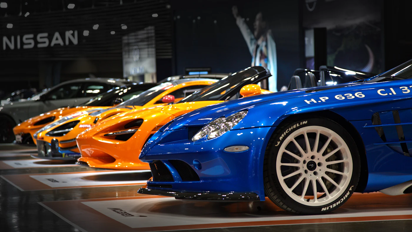 Voitures de sport exposées sous les projecteurs d’un salon automobile
