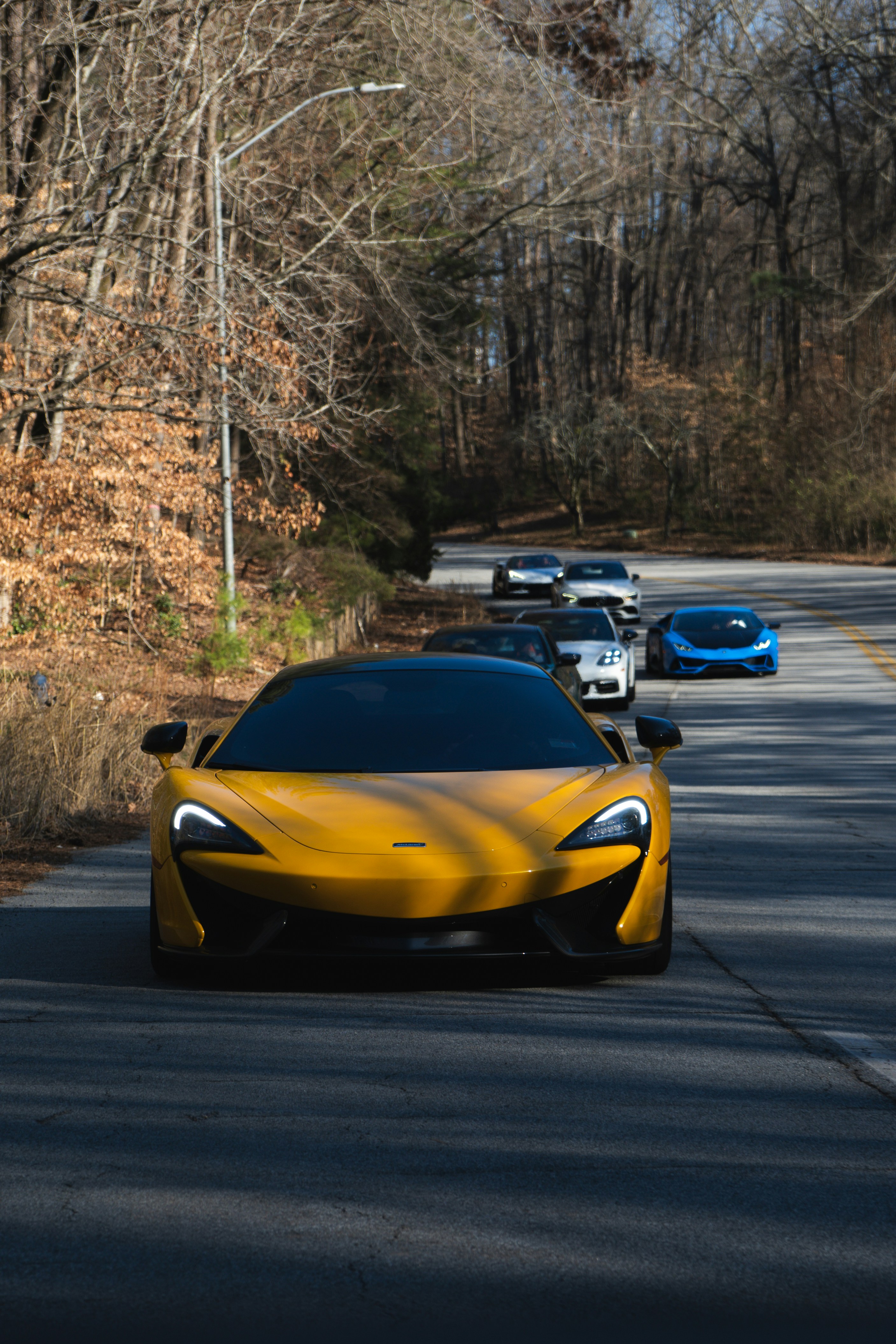 A yellow sports car driving down a road