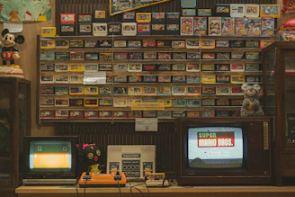 A room with two televisions, a radio, and a wall of movies