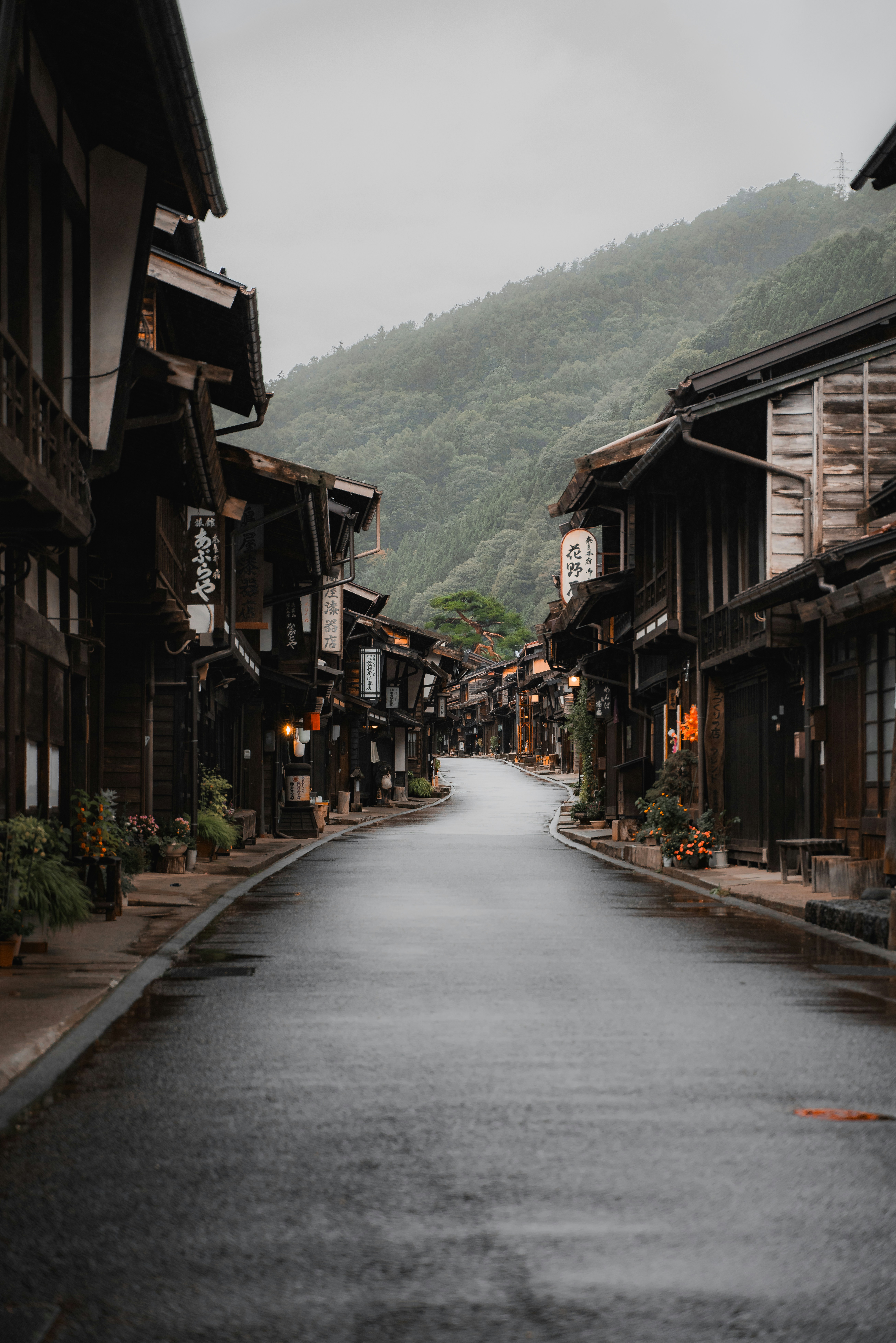 An empty street in a small town with mountains in the background