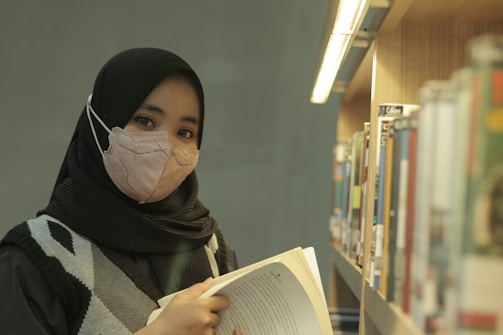 A woman reading a book in a library
