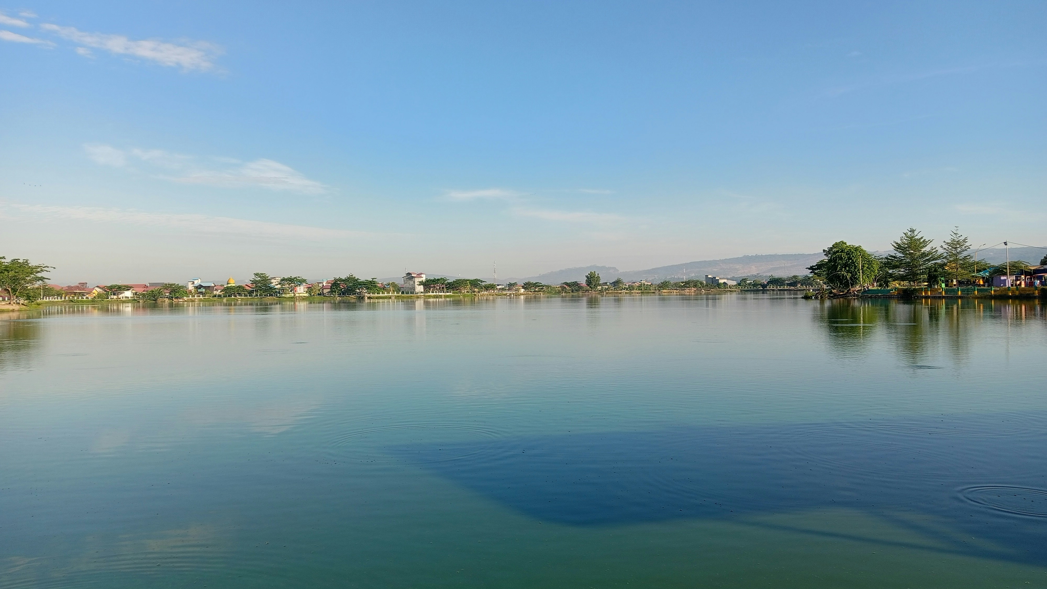 a-large-body-of-water-surrounded-by-trees-photo-free-lake-image-on
