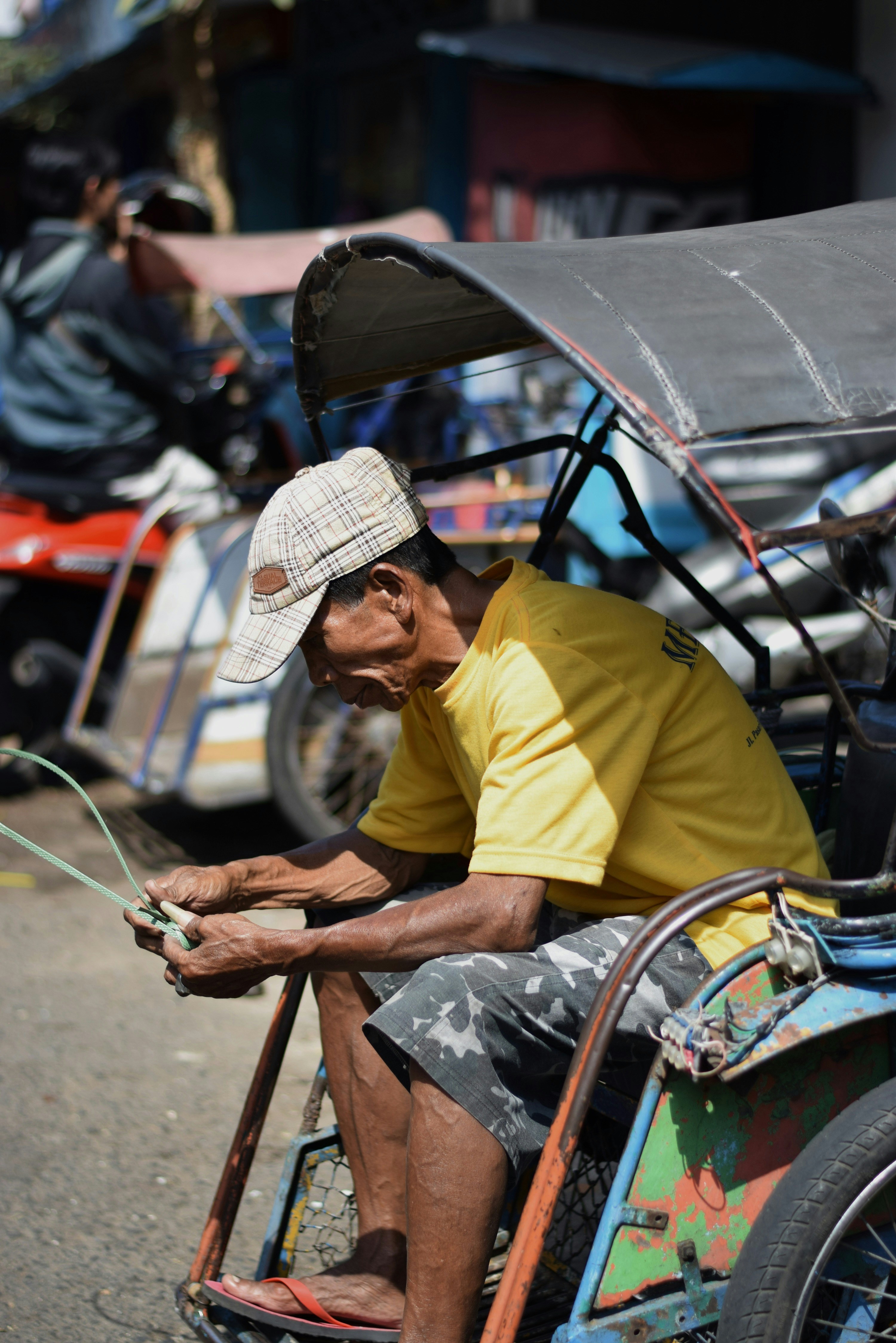 Seorang pria mengendarai sepeda dengan gerobak yang melekat padanya