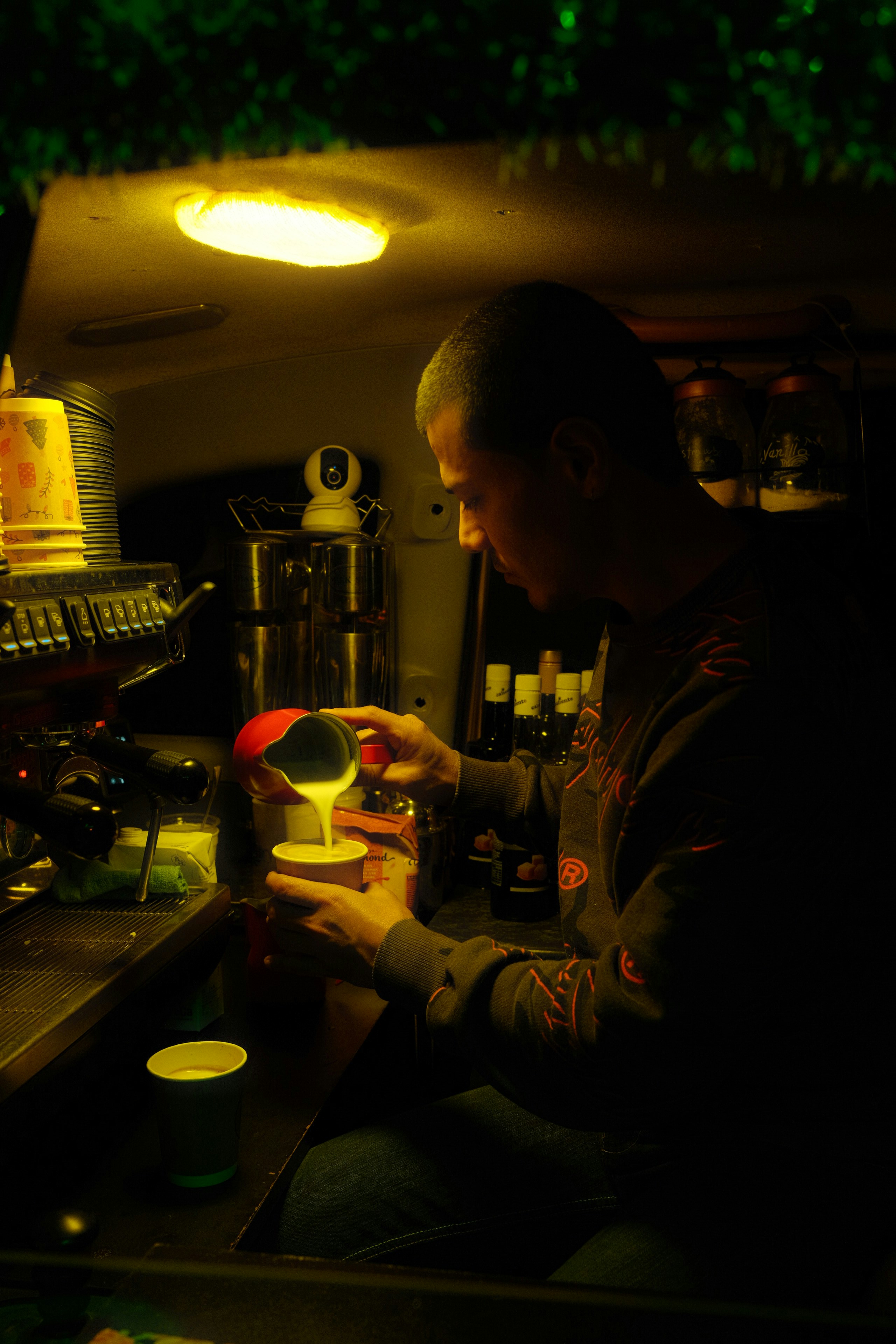 A man sitting at a bar pouring a drink